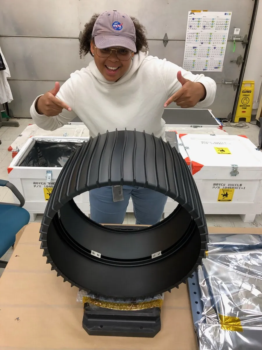 Dajae with a rover wheel at NASA JPL