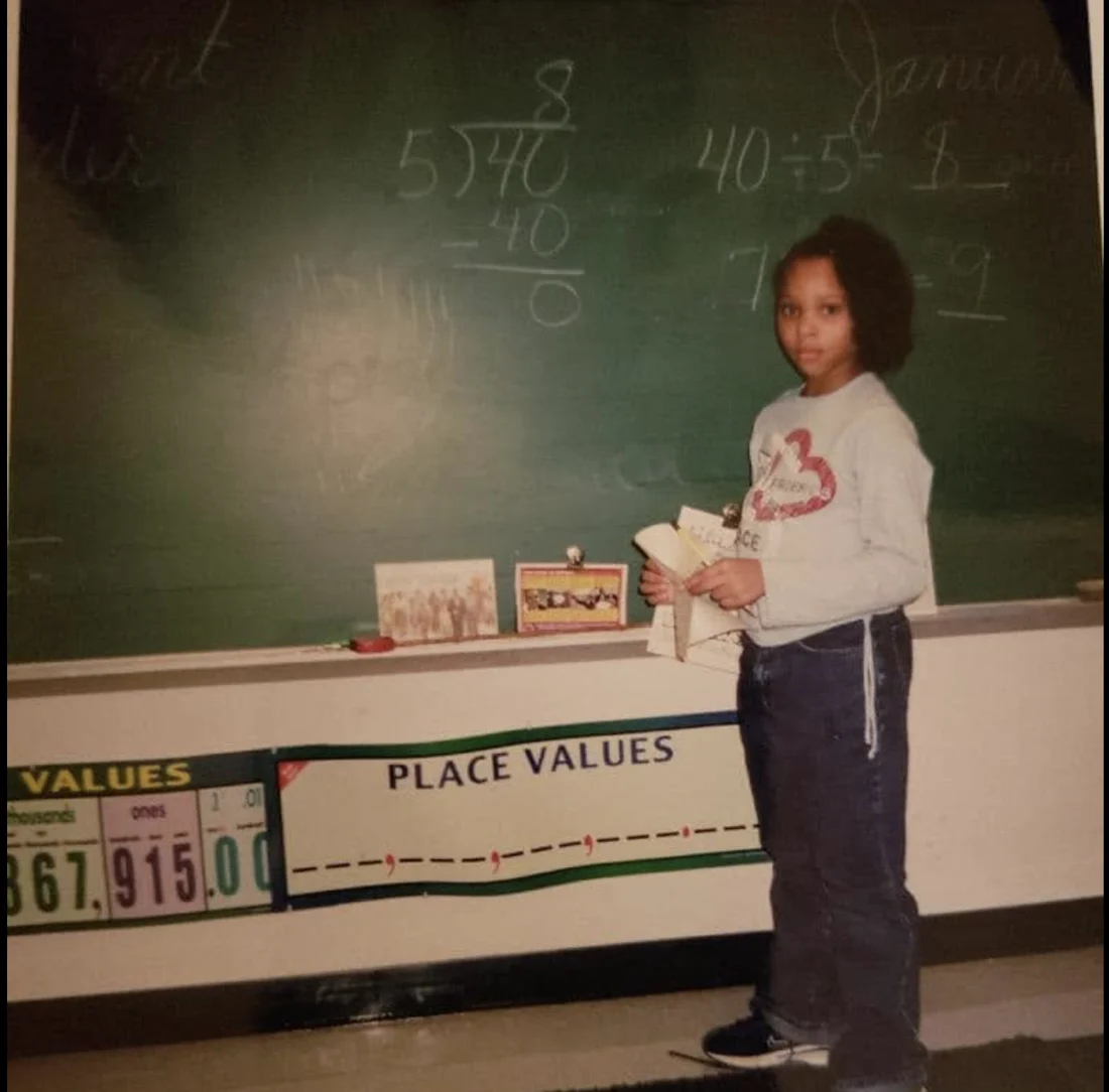 A young Dajae working a division problem at the chalkboard